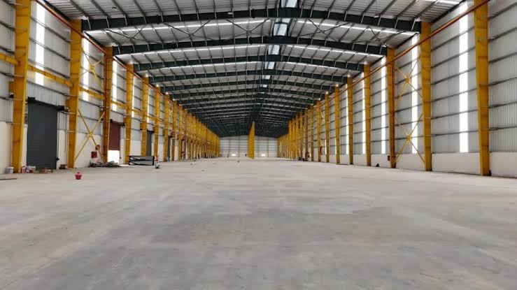 Empty industrial warehouse interior showing the metal roof deck and wall panels.